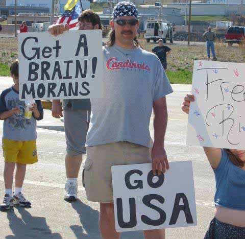 St. Louis Cardinals fan holding up a sign that says "Get a Brain! Morans"